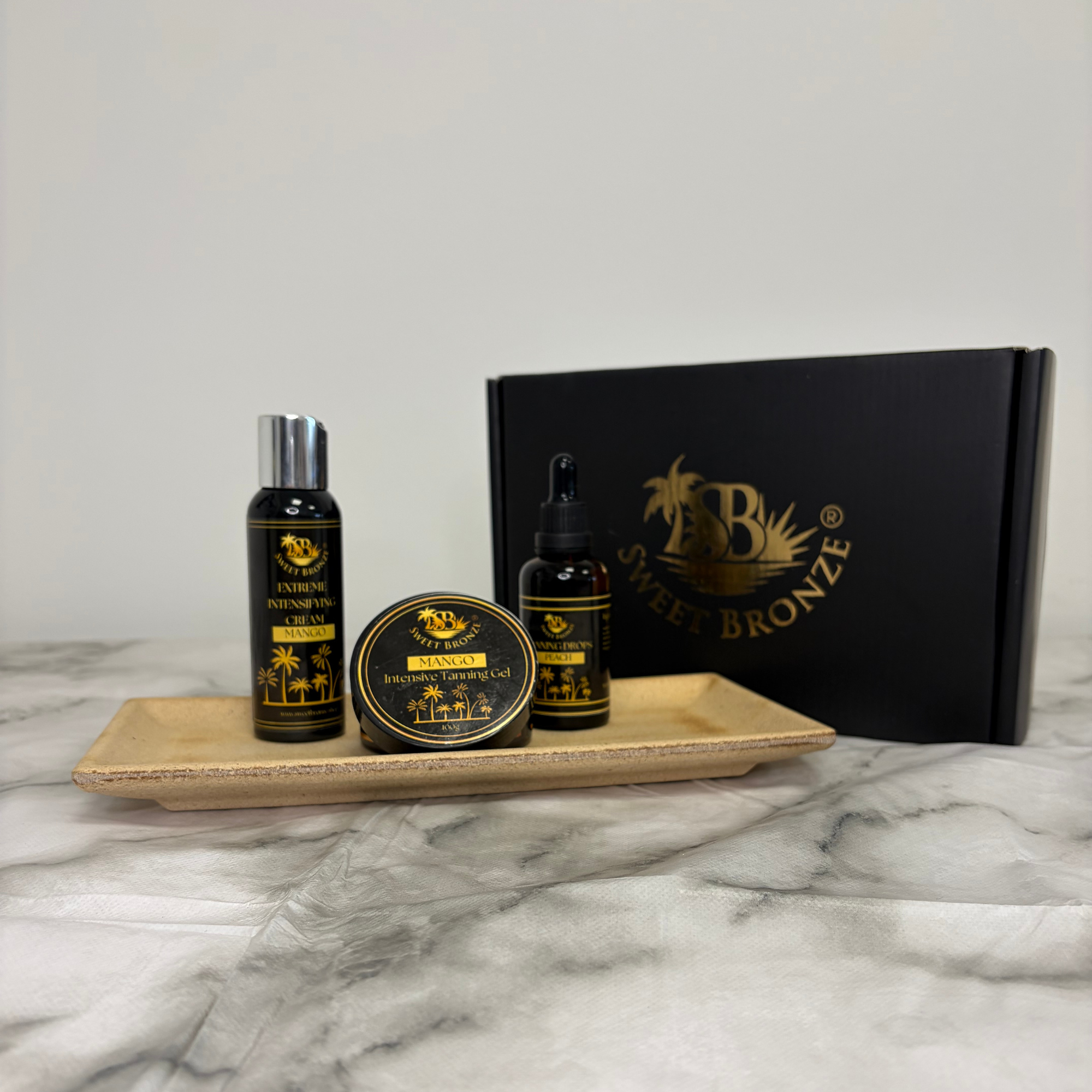 Set of beauty products including a bottle, jar, and box on a marble surface with a neutral background.